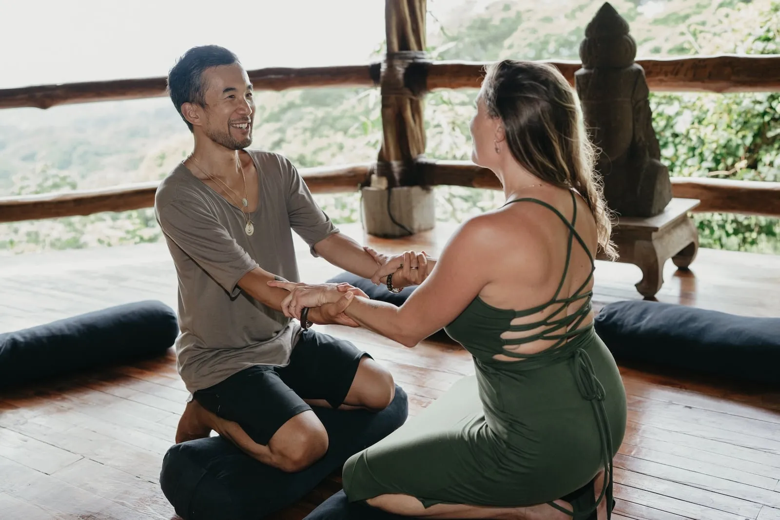 Edmond and Kiki kneeling face to face, arms clasped in the dyad practice