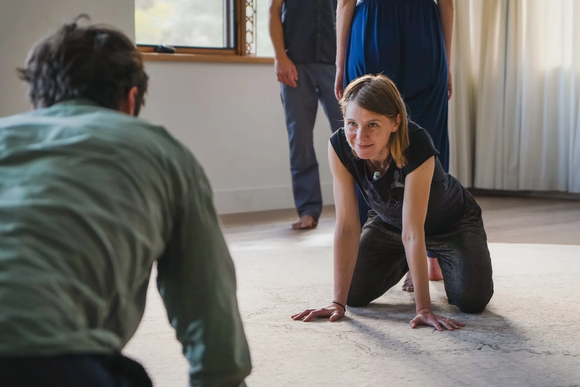 Two people meeting in embodied relational practice on the floor, held by the circle